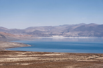 Peaceful view of the lake Pelku (Paiku) with the mountains and clear blue sky in the background on the Tibetan Plateau in Shigatse Prefecture, China