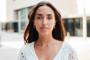 Individual portrait of a Hispanic girl with a serious expression looking at camera. Young teenage...
