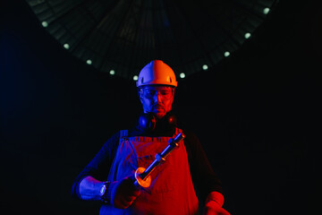 Obraz premium Worker at construction site in neon light