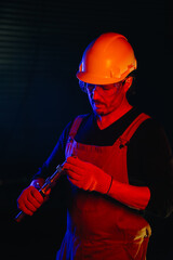 Fototapeta premium The assembly worker is illuminated by red neon light.
