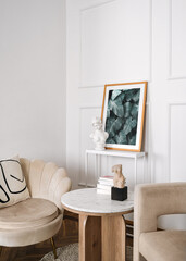 Modern living room with white walls, artwork, marble coffee table and classic chairs