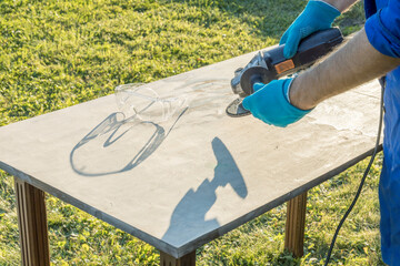 A man is using a power tool to cut a slab of concrete