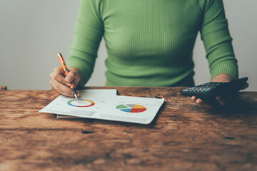 Analyzing the Data: A woman meticulously studies financial charts and graphs, her focus intense as...