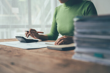 Financial Focus:  A woman diligently manages her finances, meticulously calculating expenses amidst...