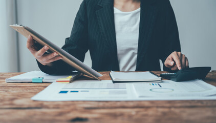 Financial Acumen: A businesswoman strategizes, meticulously analyzing data on her tablet and...