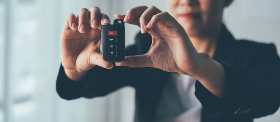 New Car Keys: Close-up of a woman's hand holding a new car key, symbolizing ownership, freedom, and exciting new beginnings. The image evokes a sense of accomplishment and anticipation.  