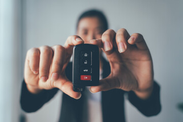 New Car Keys:  A close-up shot of a woman's hands holding a modern car key, showcasing the sleek design and advanced technology. The image evokes a sense of freedom, mobility, and new beginnings. 