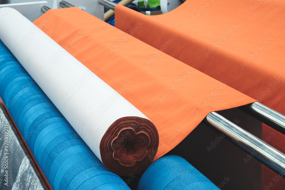 Aufkleber a roll of orange fabric is sitting on a table next to a roll of white fabric