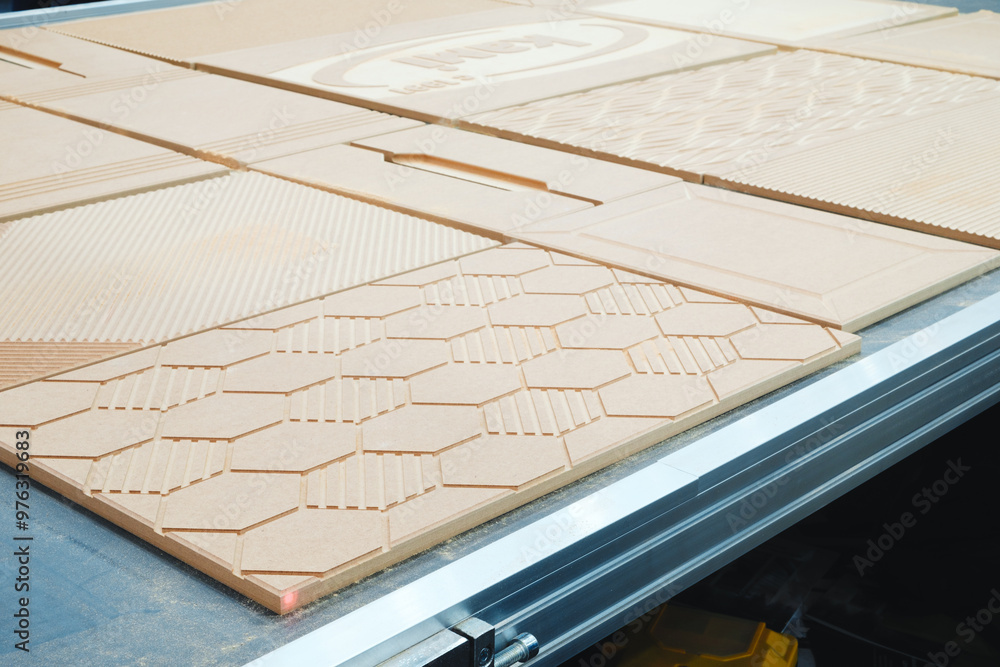 Fototapete a wooden board with a pattern of hexagons and squares is being cut by a machine. the board is being 