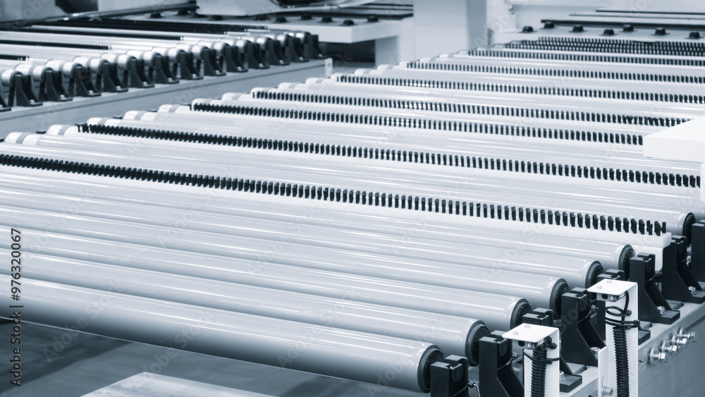 Fototapete a row of metal tubes are lined up in a factory. the tubes are white and black, and they are all the 