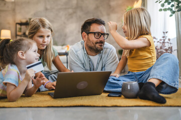 Father and daughters have online shopping on laptop with credit card