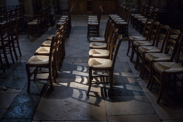 chaises alignées vides dans une église avec lumière naturelle