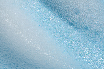 Soap cleanser foam texture. soft shampoo bubbles on blue background. Cosmetic foamy cleansing...