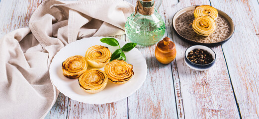 Caramelized roasted onions and basil on a plate on the table web banner
