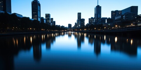 Naklejka premium A beautiful city skyline reflected on calm water during twilight, highlighting the serene atmosphere, urban architecture, and the beauty of cityscapes at dusk or dawn.