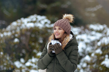 happy modern woman outdoors in city park in winter