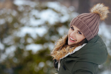 smiling modern woman outdoors in city park in winter