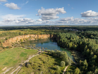 Obraz premium Aerial drone photo of Quarry turquiose lake colour, open pit mining in Park Grodek, Jaworzno. Poland. Turquiose Water and Wooden Bridge on lake. Polish Maldives Park Grodek in Jaworzno from drone.