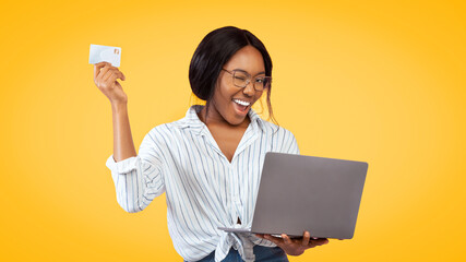Online Shopping Concept. Joyful Black Girl Holding Laptop And Credit Card Standing Over Pink Studio Background. Panorama
