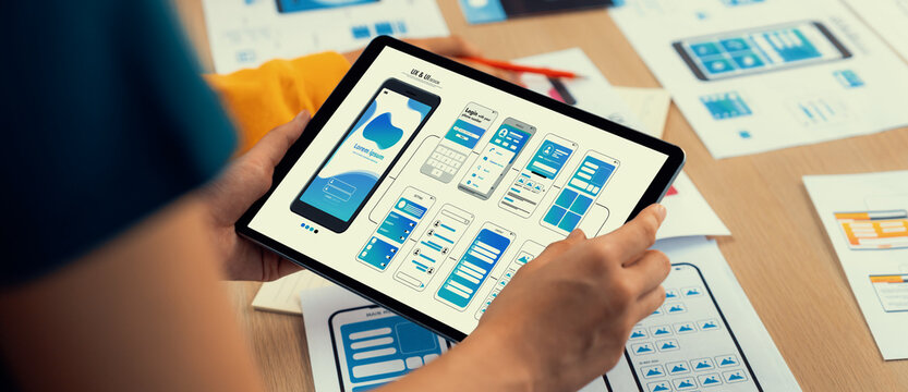 Panorama banner of startup UX developer or company employee design user interface or UI prototype for mobile application or website software with software display on tablet screen in office. Synergic