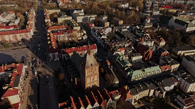 The drone captures Koszalin&rsquo;s bustling Zwycięstwa Street, Ratusz, and a Gothic cathedral on a bright day.