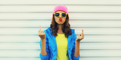 Portrait of bad angry young woman expression showing hand with middle finger sign, stylish girl
