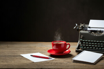 An old typewriter, notepad, pen and a cup of coffee.