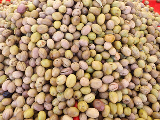 Types of olives for sale in market, green and black olives on sales table, delicious Mediterranean olive, Mix Assorted colorful olives lined up on local street market counter in algiers Algeria.