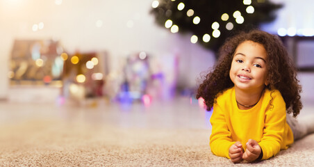 Cute friendly afro little girl resting near awesome Christmas offer, empty space