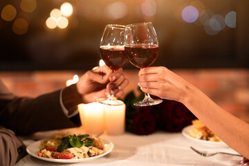 Celebrating Valentine's Day. Unrecognizable Couple In Love Clinking Glasses Drinking Wine On Romantic Date In Restaurant. Cropped
