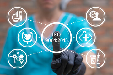 Doctor using virtual touch screen presses text: ISO 9001:2015. Healthcare international quality standards. ISO 9001:2015 standard certification standardization quality control medical concept.