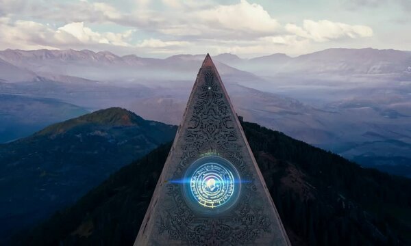 Futuristic monument with shining sacred symbols on a hill surrounded by majestic landscape. Fantasy scene full of mystery
