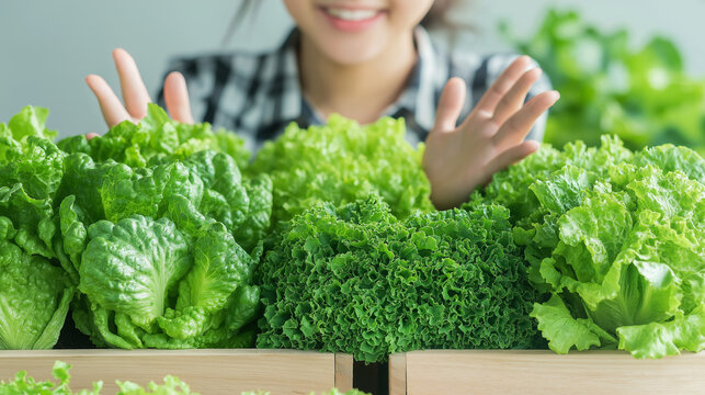 Cheerful young Asian woman gardener, wearing a plaid shirt, leaning over a raised bed of fresh lettuce. She's expressing excitement with her hands raised near her face open the both palm of the hands, - Powered by Adobe