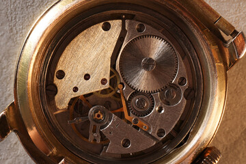 Mechanism of vintage wrist watch on beige background, top view