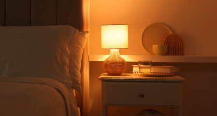 Stylish living room interior with bed, bedside table and lamp