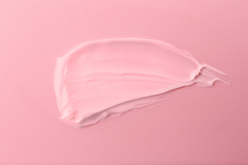 Sample of face cream on pink background, top view