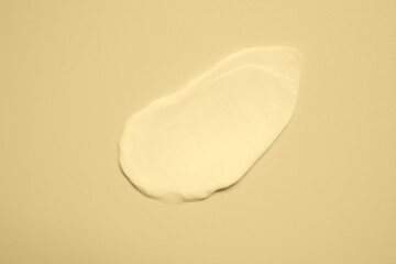 Sample of face cream on beige background, top view
