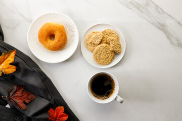 Cup of black coffee, Donut, .Cookies, leaves, on white marble background. Autumn composition. Copy space. Flat lay. Top view.
