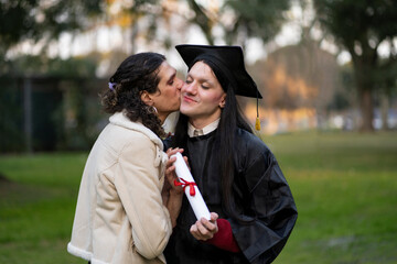 Transgender woman recent graduated, dressed in cap and gown, showing off his degree celebrating...