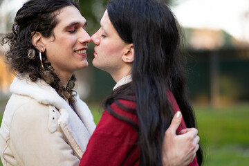 Transgender couple about to kiss in a park