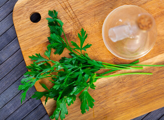 Bundle of fresh parsley on wooden background, aromatic herbs prepared for cooking