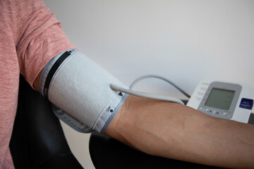 Man performs self-monitoring of blood pressure with a tensiometer