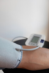 Young man performing a blood pressure auto test / man self-monitoring of blood pressure with a tensiometer