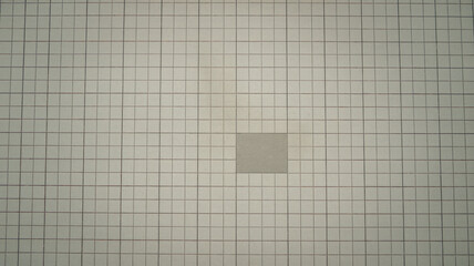 A photo of a clean background with a lot of negative space. The background is a light gray surface with a few small, dark gray squares scattered across it. The overall image has a minimalistic