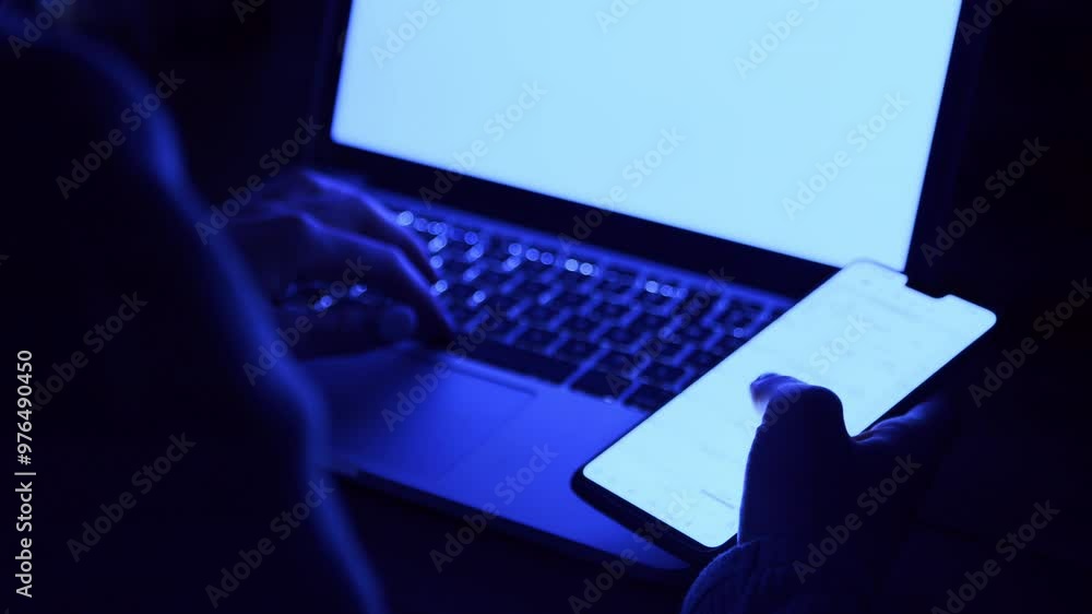 Poster a person engages with a smartphone in one hand while typing on a laptop, surrounded by a soft blue l