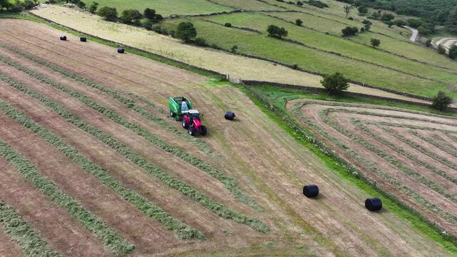 Aerial View of a Massey Ferguson 6480 tractor Baling silage with a McHale fusion 3 Baler wrapper at Ballygawn farm Co Antrim Northern Ireland 14-09-24
