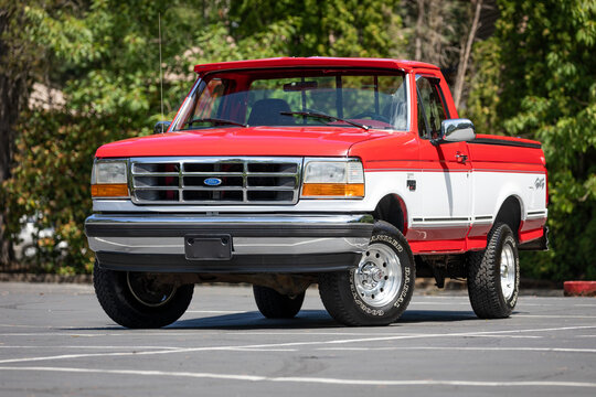 Portland, OR, USA - July 17, 2021 - 1995 Red White Ford F150 XLT pickup truck American 4X4 SUV off-road vehicle exterior. High quality picture for download.