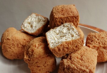 Fried tofu in whole and halves served on a plate. Tofu named Tahu Pong from Indonesia. 