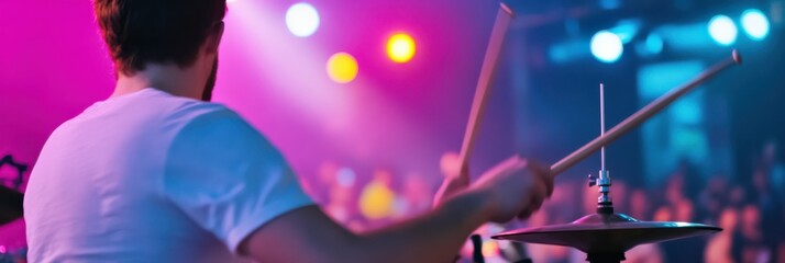 A dynamic image of a musician energetically playing drums on stage amidst colorful lights, capturing the essence of live performance, music passion, and audience engagement.