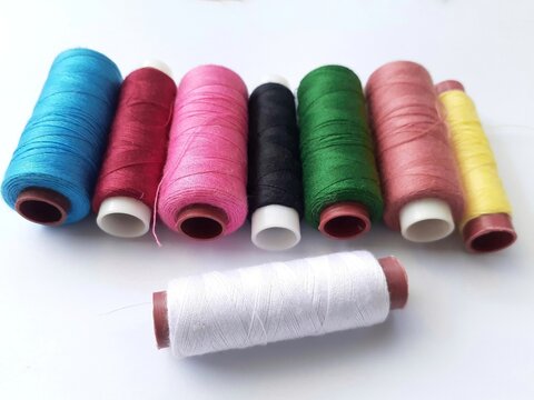 Collection of sewing threads in rolls of various colors isolated on white background.